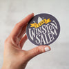 I love Winston-Salem round vinyl sticker in charcoal grey and yellow by Em Dash Paper Co.